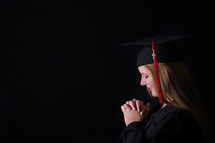 portrait of a graduate with praying hands 