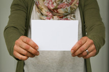 a woman holding up an envelope