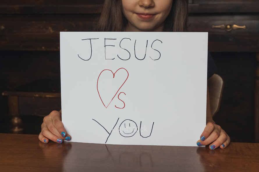 Girl holding a Jesus loves you sign