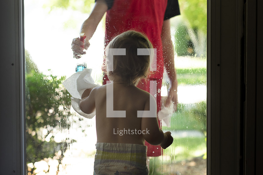toddler cleaning a window 
