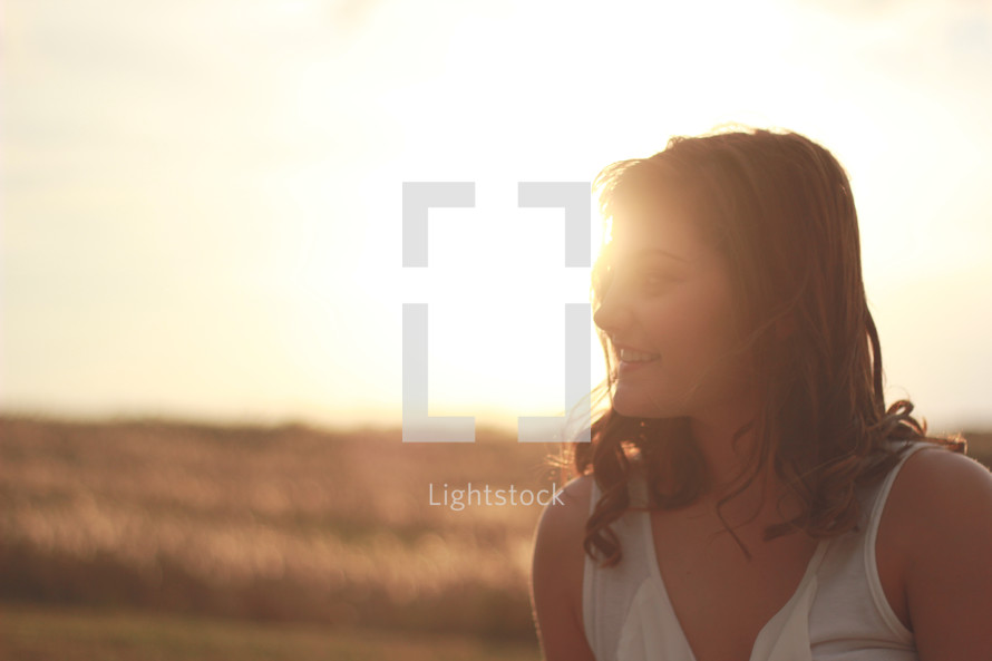 sunlight on the face of a smiling young woman 