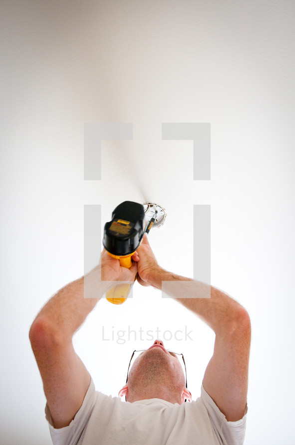man using an electric screw driver 