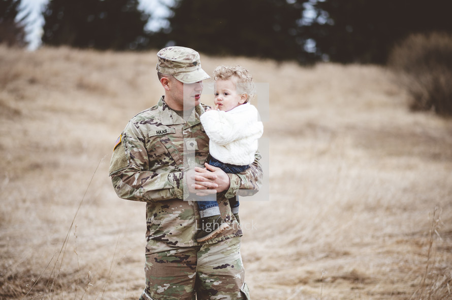 military dad holding his son 