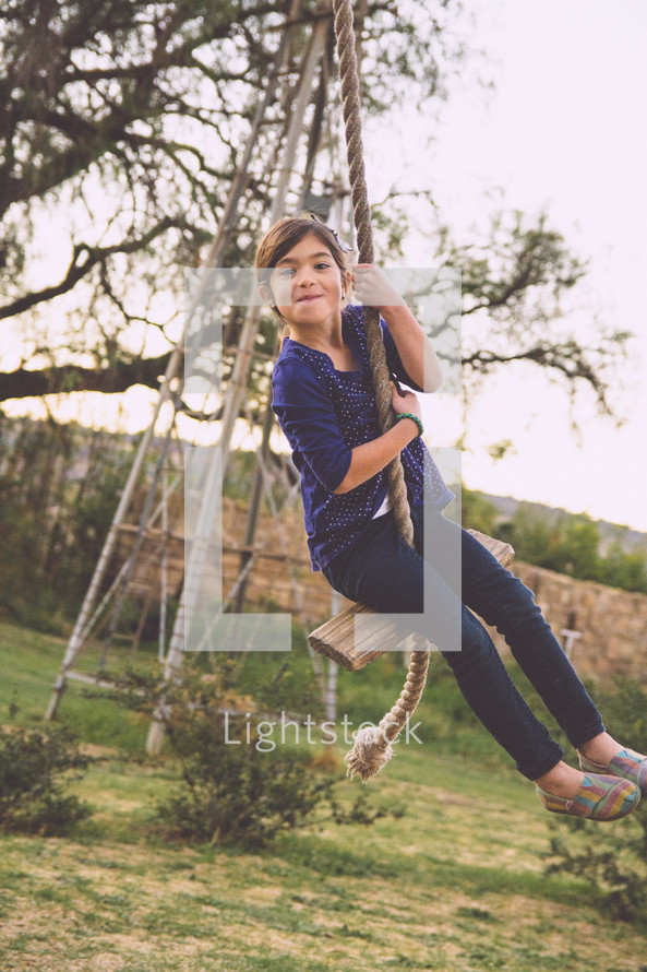 girl child on a rope swing 