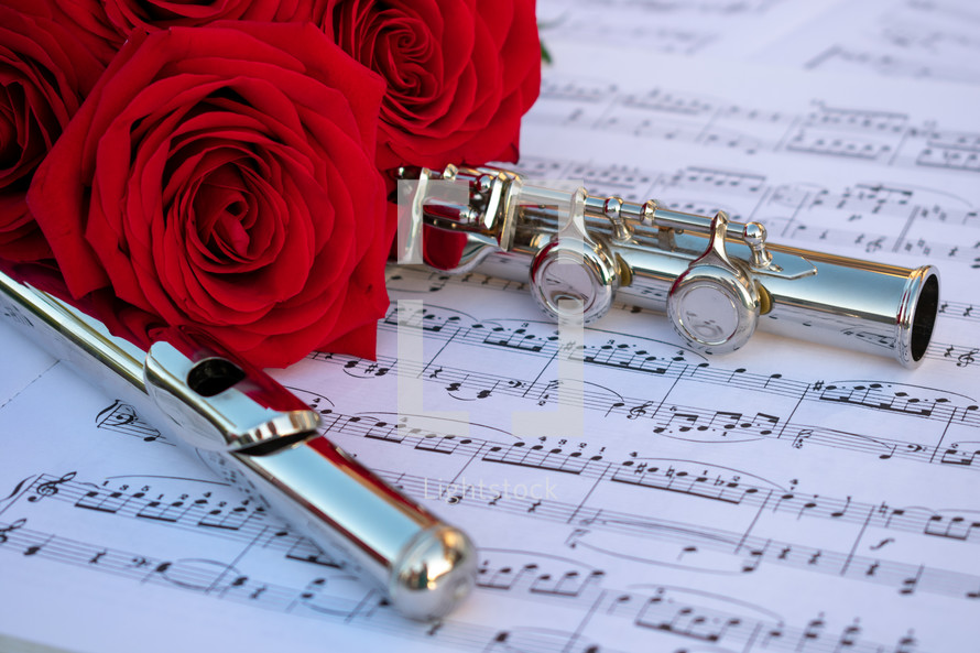 red rose and flute on sheet music 
