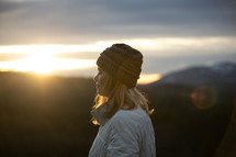 woman praying on a mountaintop at sunset 