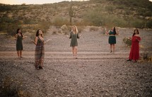 women socially distancing praying in a desert 