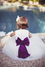 flower girl sitting by a pool