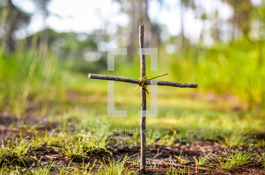 cross made from sticks and twine in the ground