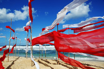 red and white banners waving on a beach 