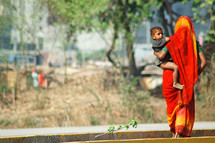 mother carrying her toddler in india 