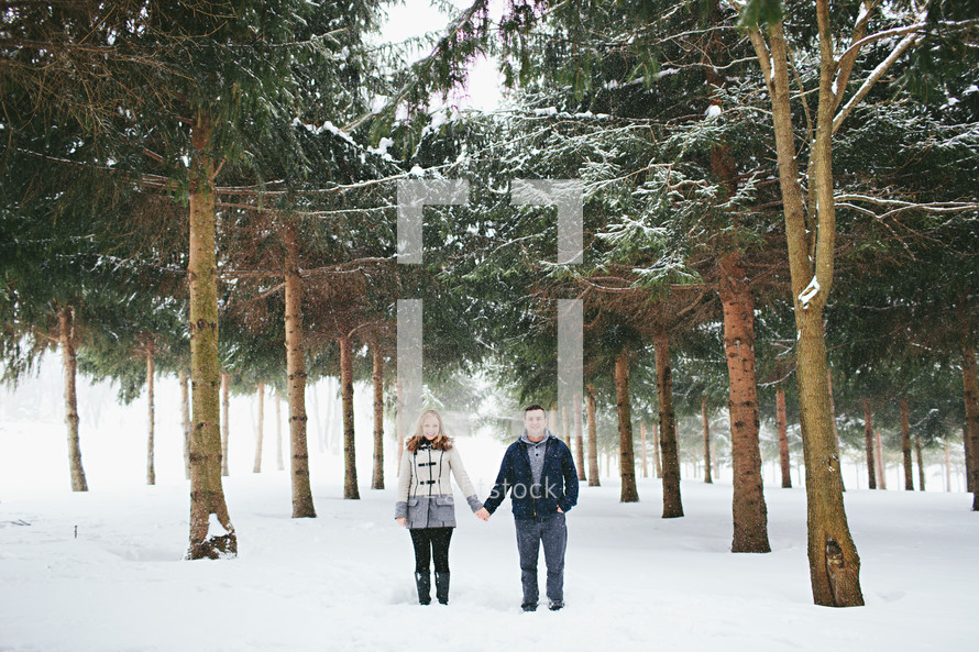 a couple holding hands in snow 