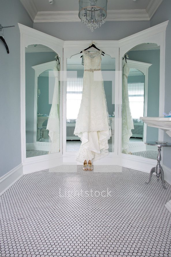 a wedding dress hanging in a mirror 