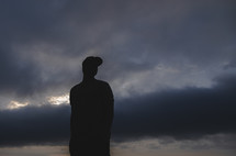 silhouette of a man standing in a storm 