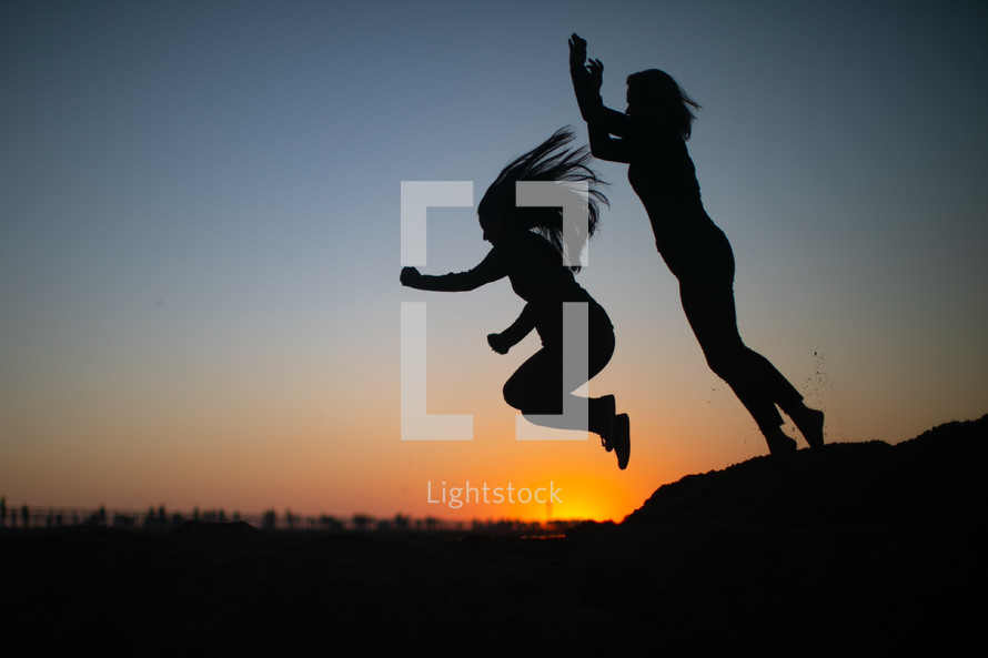 silhouettes of women jumping 