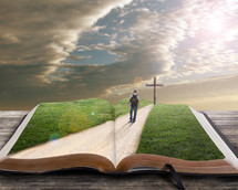 man on a spiritual journey walking down a road towards a cross standing on a Bible