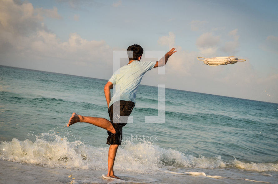 man tossing a life ring into the ocean
