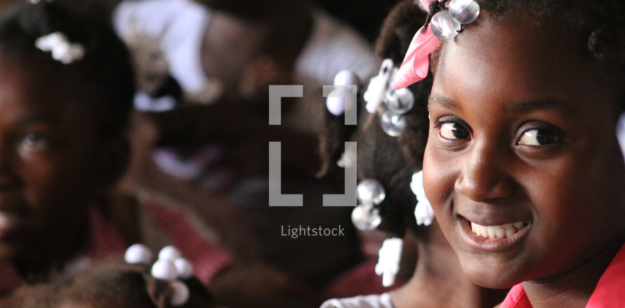 faces of smiling girls in Haiti 