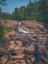a man watching water flowing over rocks