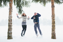 a couple jumping in the snow 