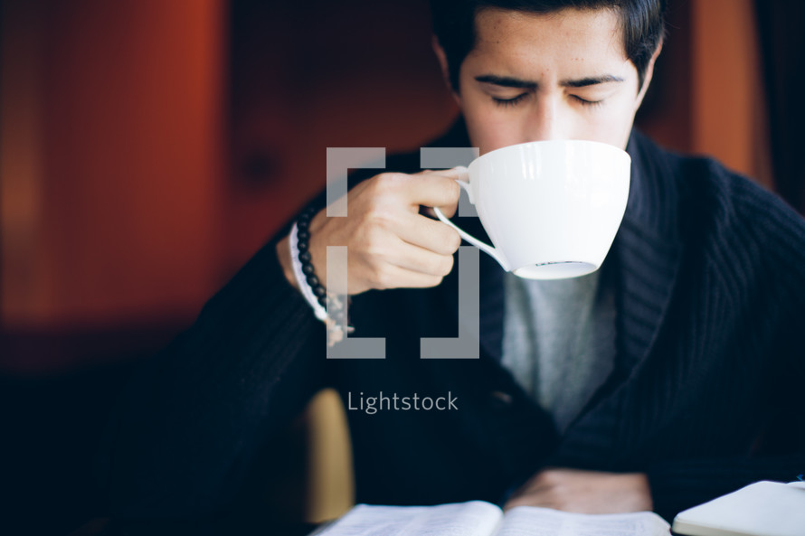 man holding a coffee mug to his mouth