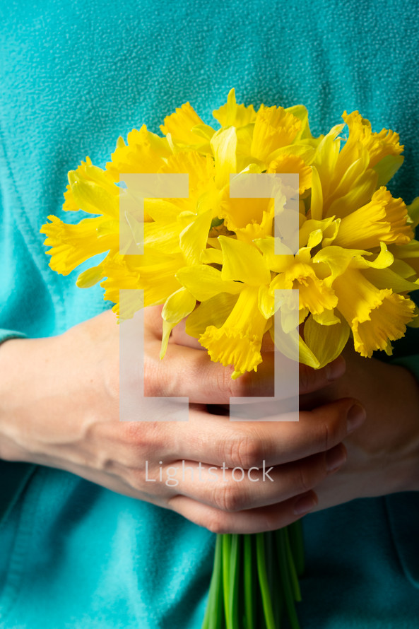 girl holding yellow daffodils 