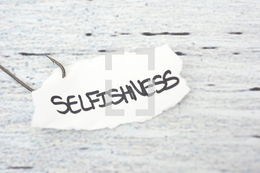 fish hook on paper with the word selfishness 