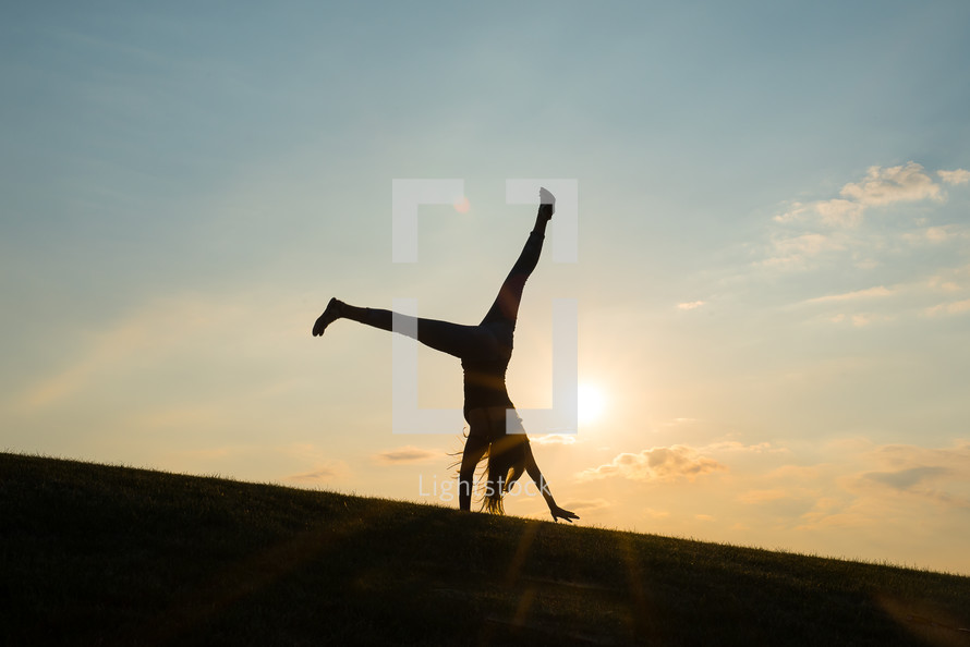 silhouette of a woman doing a cartwheel 