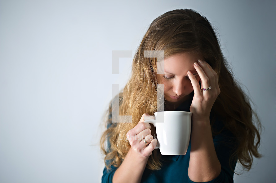 stressed woman holding a mug of coffee