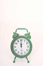 green alarm clock at 12:00