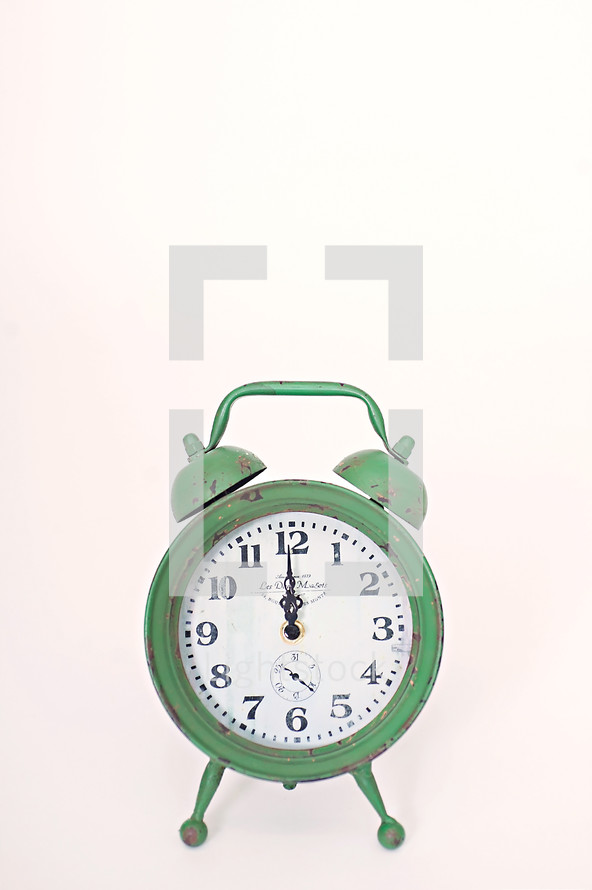 green alarm clock at 12:00