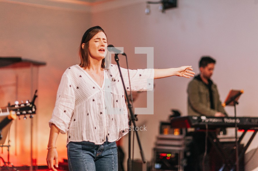 worship leaders singing on stage at a worship service 