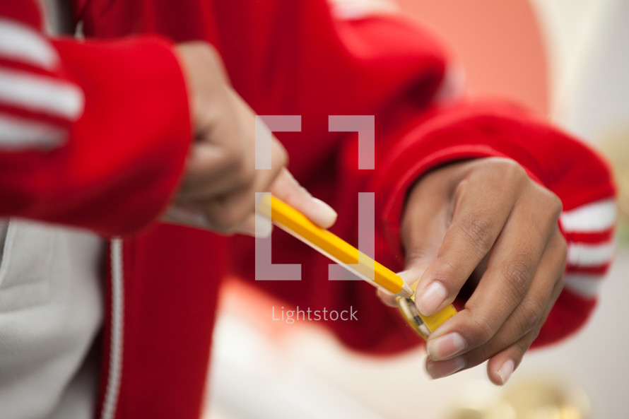 child sharpening a pencil 