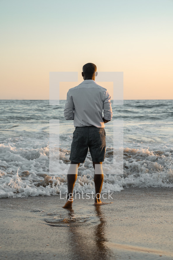man standing in the ocean 