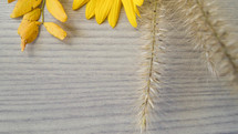 yellow fall leaves and grasses on a wood background 