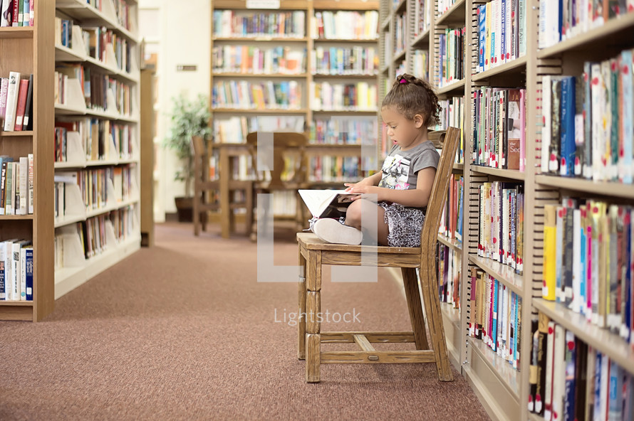 girl child reading in a library 