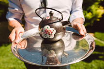 Serving tea on a silver platter.