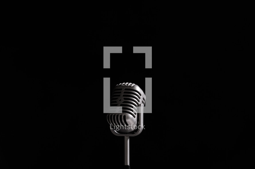 Vintage style microphone on black background. 