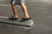 child balancing on concrete barrier 