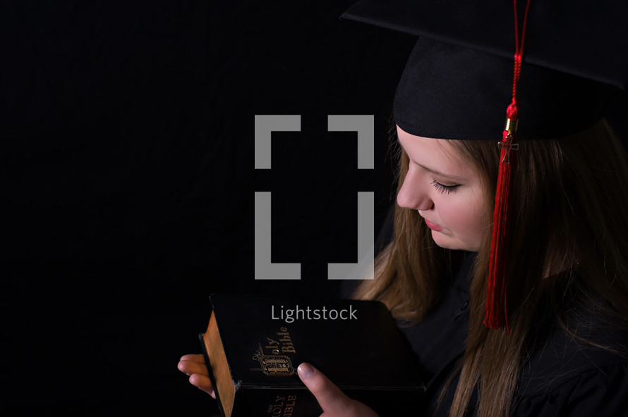 face of a graduate holding a Bible 