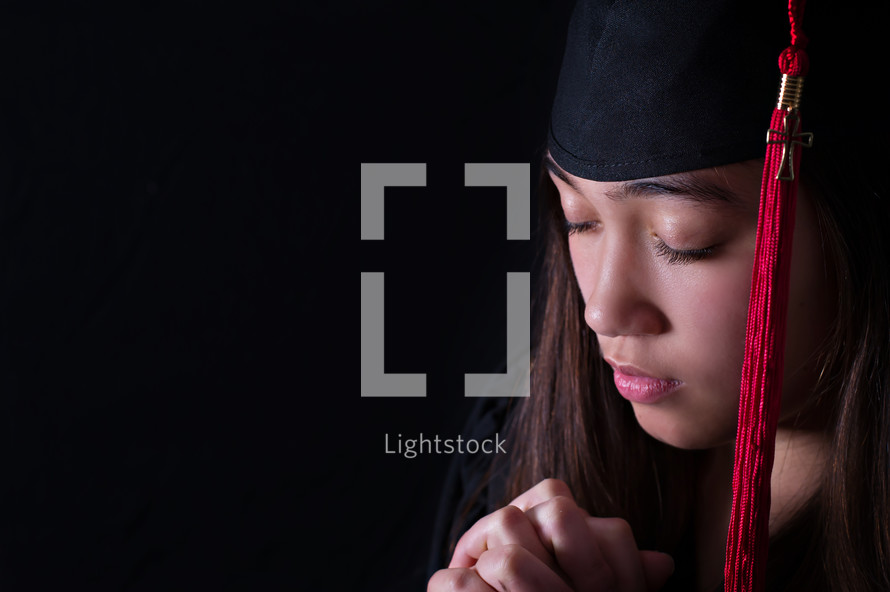 face of a graduate with praying hands 