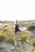 couple walking on sand dunes 