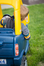 toddler boy in a toy ride on car 