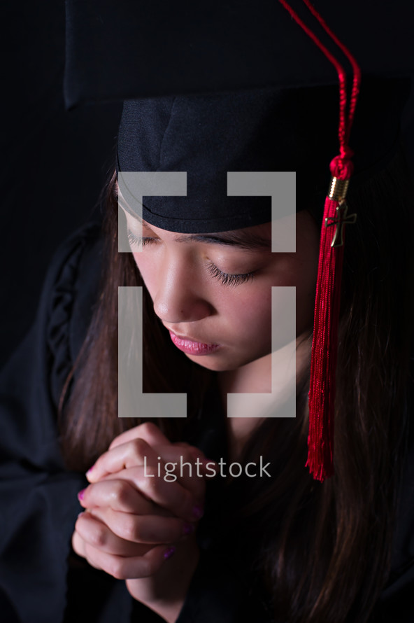 face of a female graduate in prayer