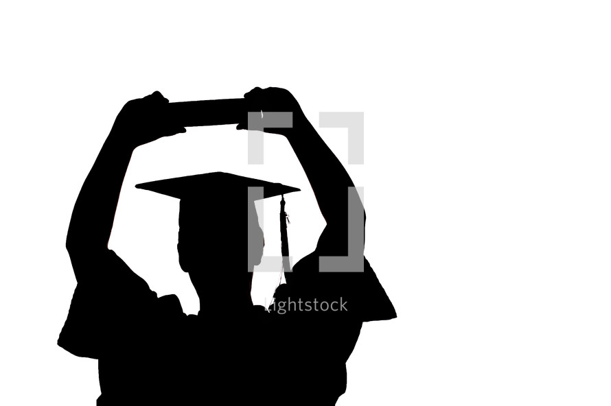 male graduate with Bible raised above his head 