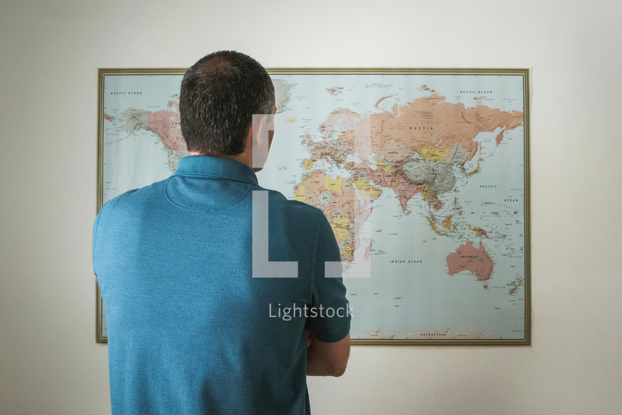 a man standing in front of a world map 