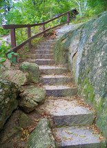 A path covered in stone steps outdoors along a narrow wooded passageway along the James River in Richmond, Virginia. 