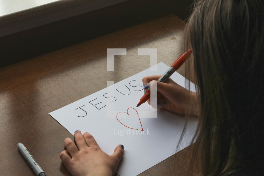 Child drawing a Jesus sign 