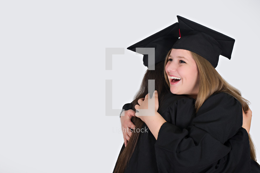graduates hugging 