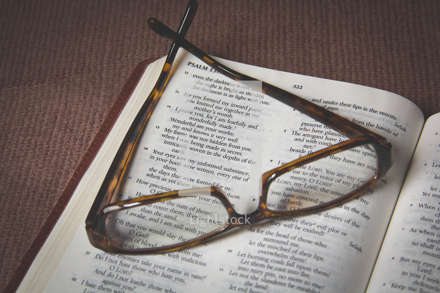 Reading glasses on a Bible open to Psalm 139.